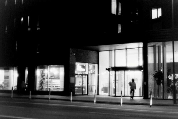 Night photo of a person entering a building.