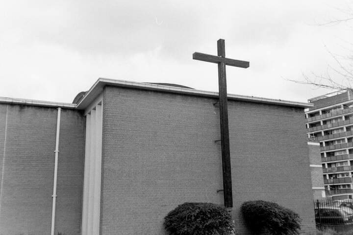 A church with a large and oddly proportioned cross on the side.