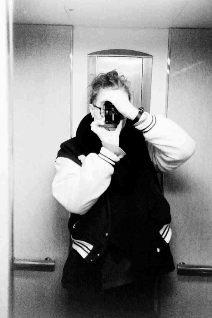 Selfie. A woman in a lift with her tongue sticking out, camera to her face.
